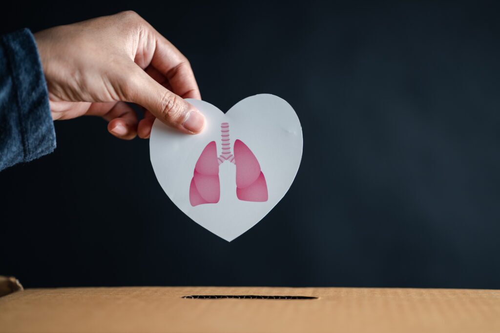 Hand drops lung in heart into donation box