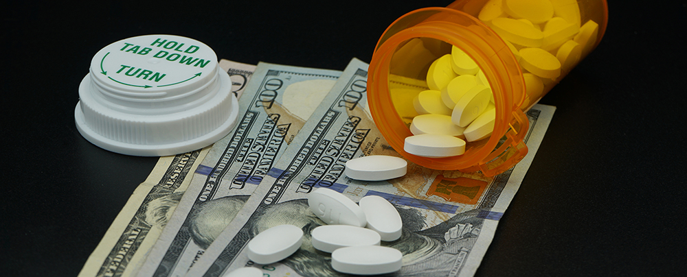 Patients Fight to Keep Medications Covered Pills and pill bottle on currency illustrating high cost of medicine